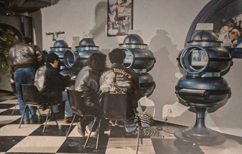 Young people seated at Dialogos terminals in a venue, early 1990s