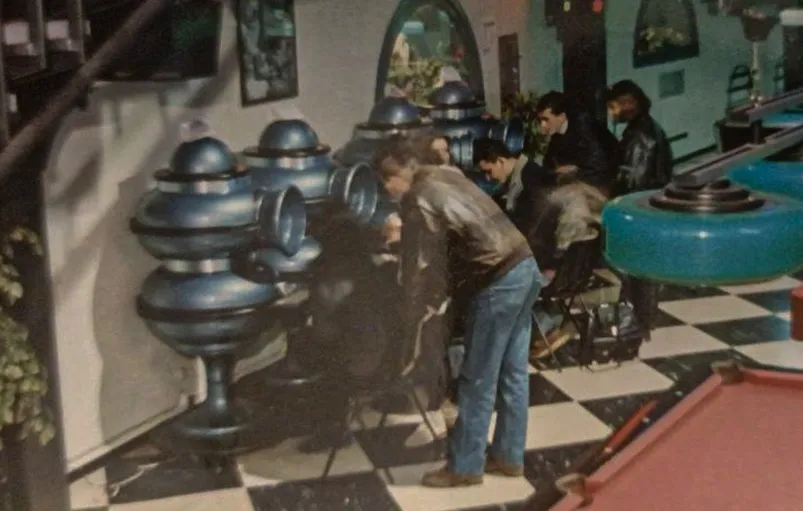 People around Dialogos terminals next to a pool table