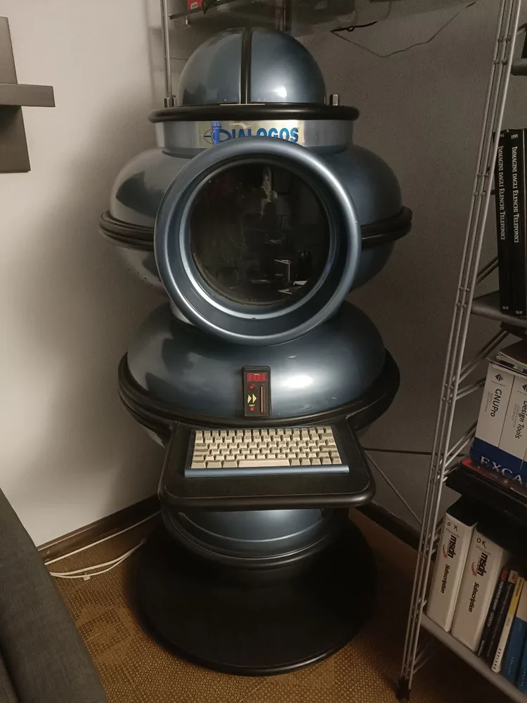 The preserved Dialogos prototype terminal: metallic-blue resin shell, circular porthole housing the monitor, and integrated keyboard